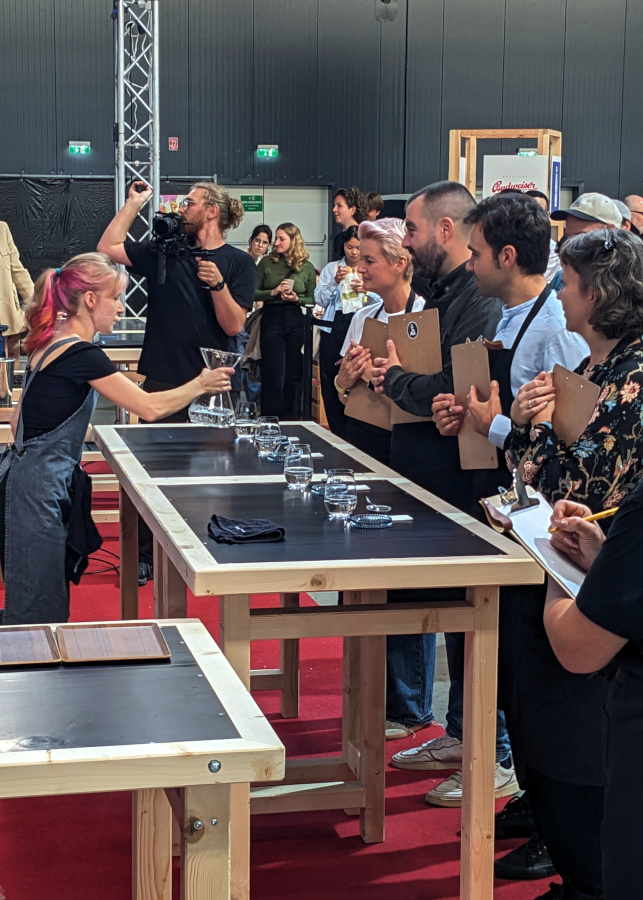 A woman is presenting her barista skills in front of a four-person jury
